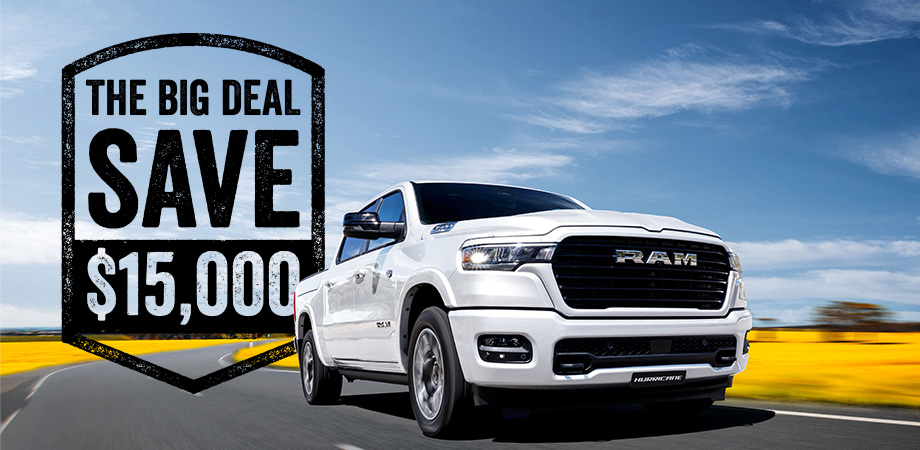 A white RAM truck driving on a road witha savings badge design behind it